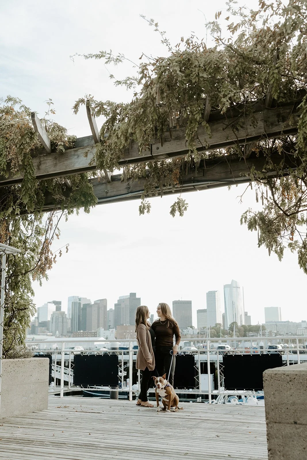 A couple posing for engagement photos in Charlestown, Boston with their dog