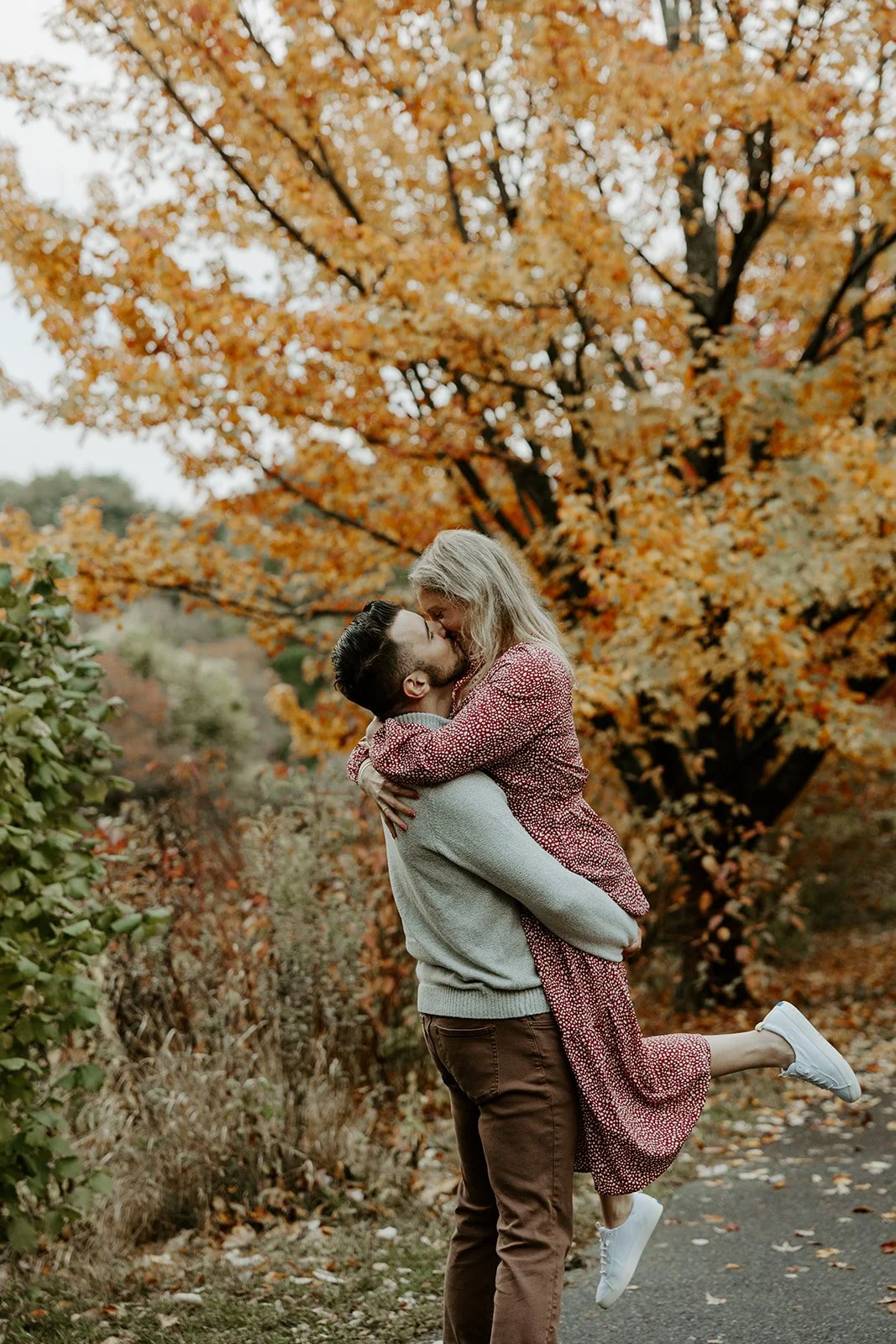 A couple posing for engagement photos at the Arnold Arboretum
