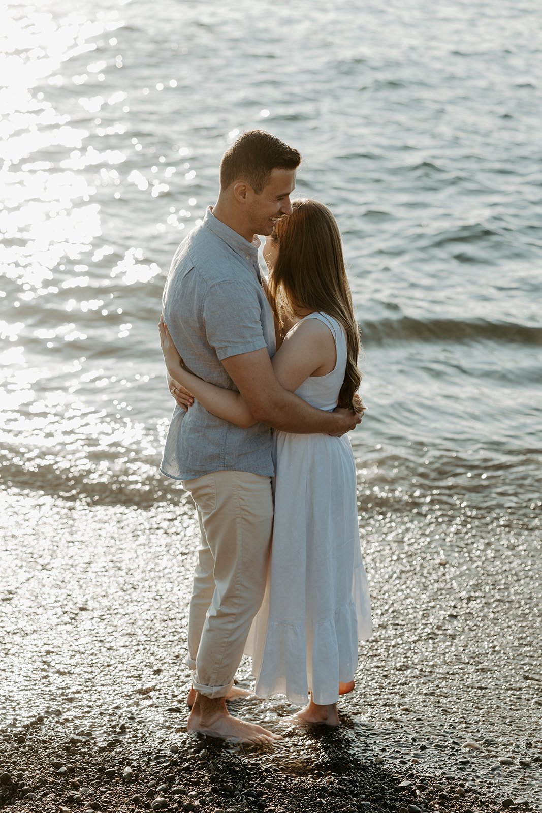 A couple posing for beach engagement photos at Castle Rock
