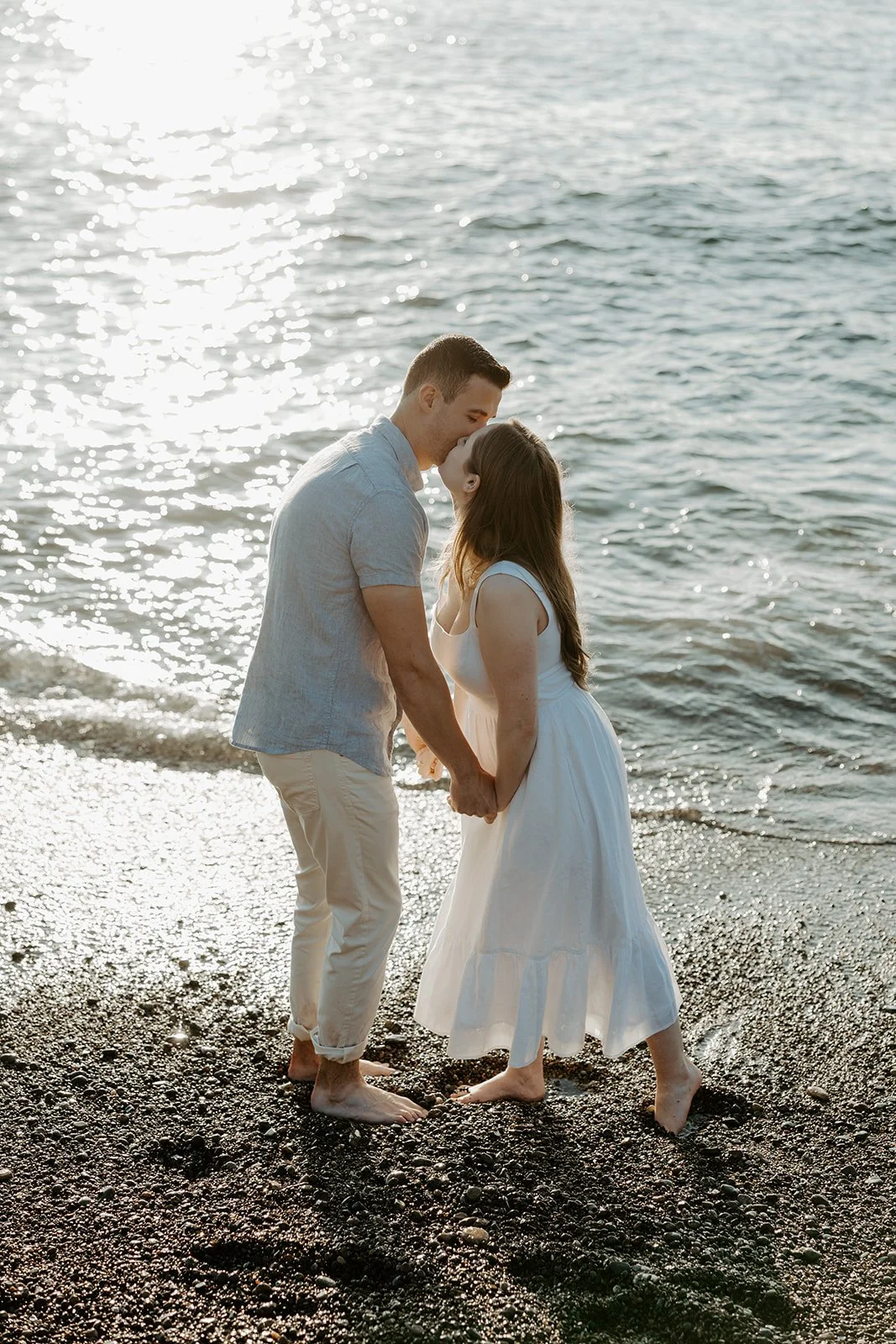 A couple posing for beach engagement photos at Castle Rock