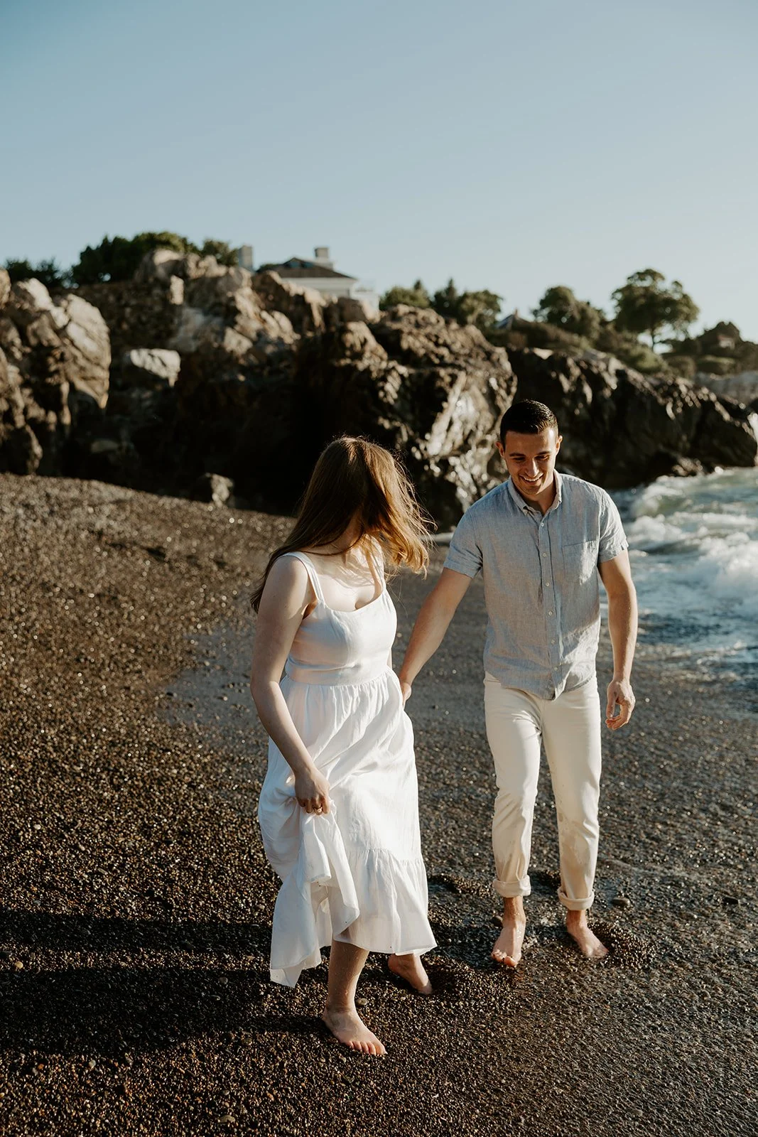 A couple posing for beach engagement photos at Castle Rock