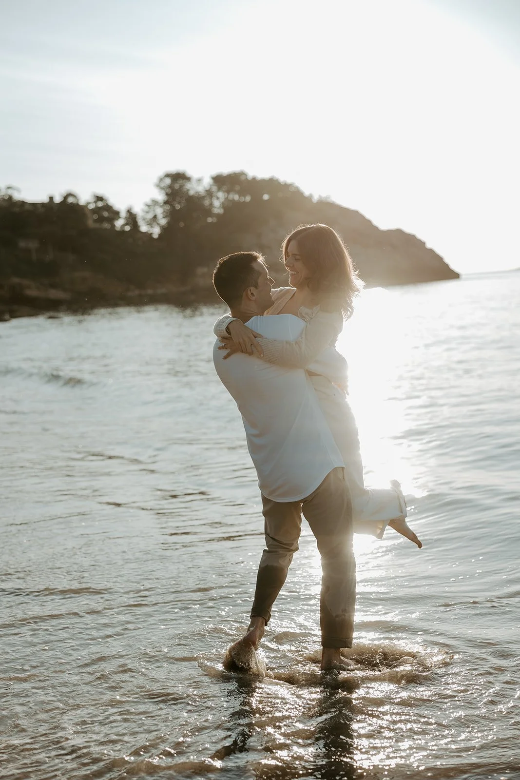 A couple taking beach engagement photos at Singing Beach 