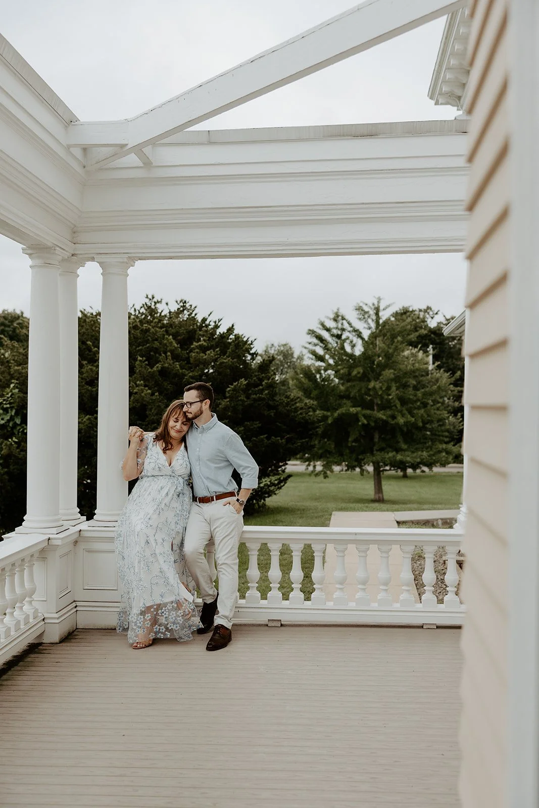 A couple taking engagement photos on the porch at Endicott Estate