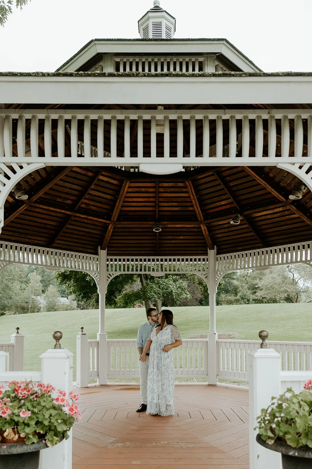 A couple taking engagement photos on the gazebo at Endicott Estate