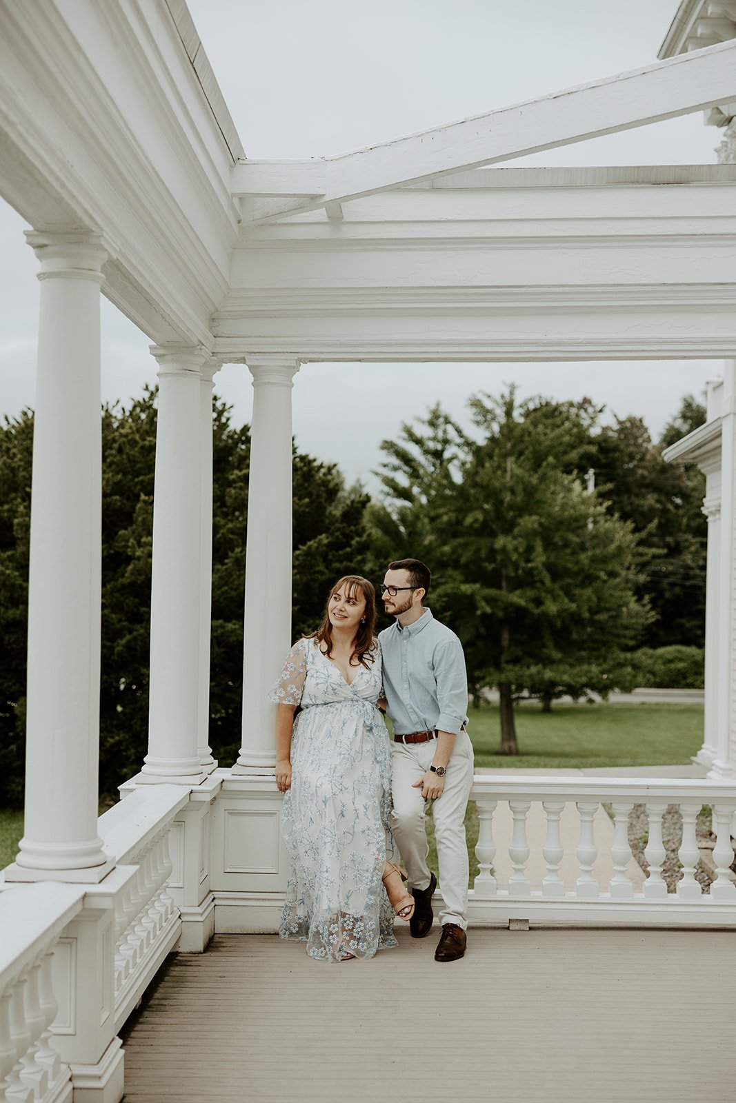 A couple taking engagement photos on the porch at Endicott Estate
