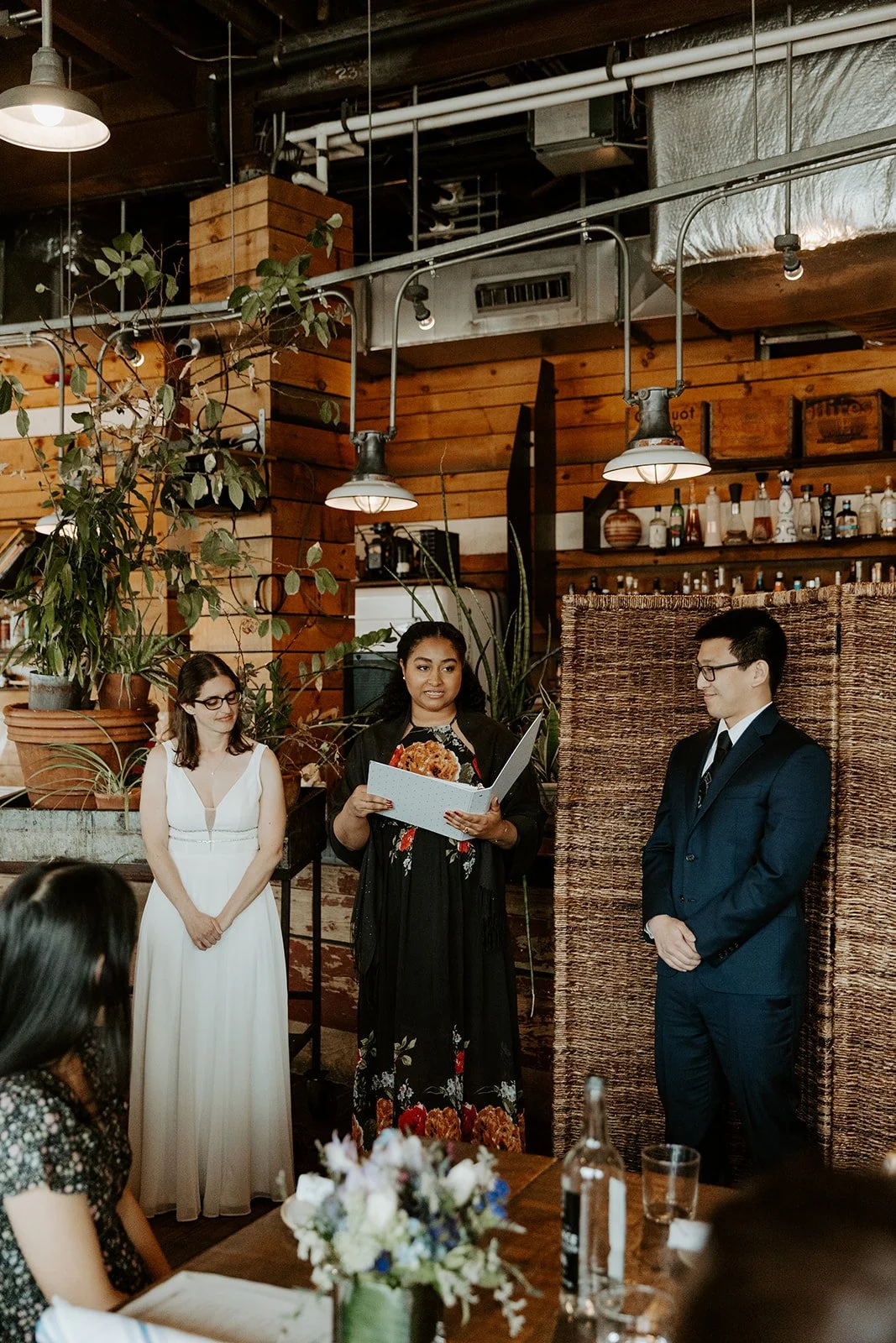 A bride and groom standing up for their restaurant wedding ceremony