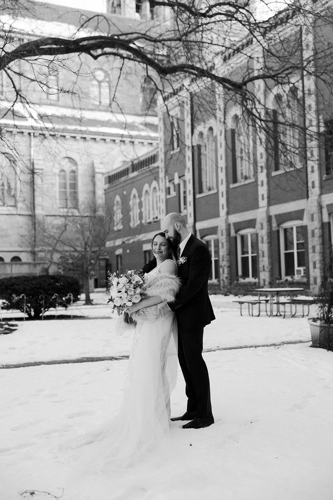 A black and white photo of a bride and groom in the snow