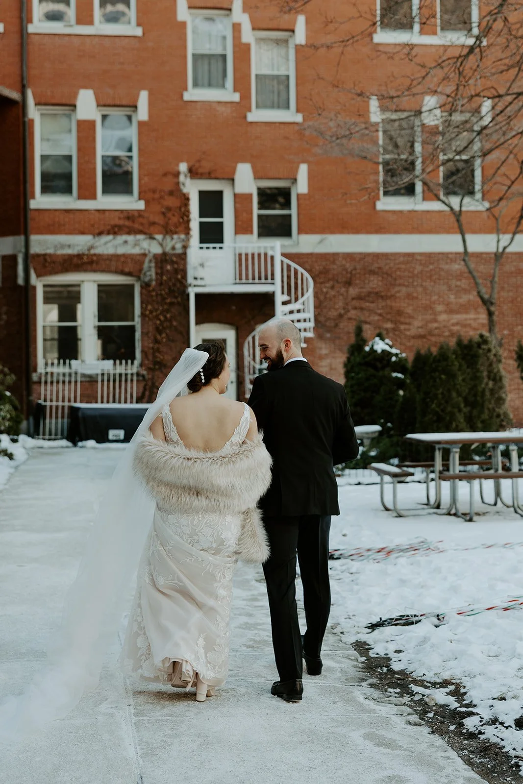 A bride and groom walking towards their wedding venue for their off season wedding