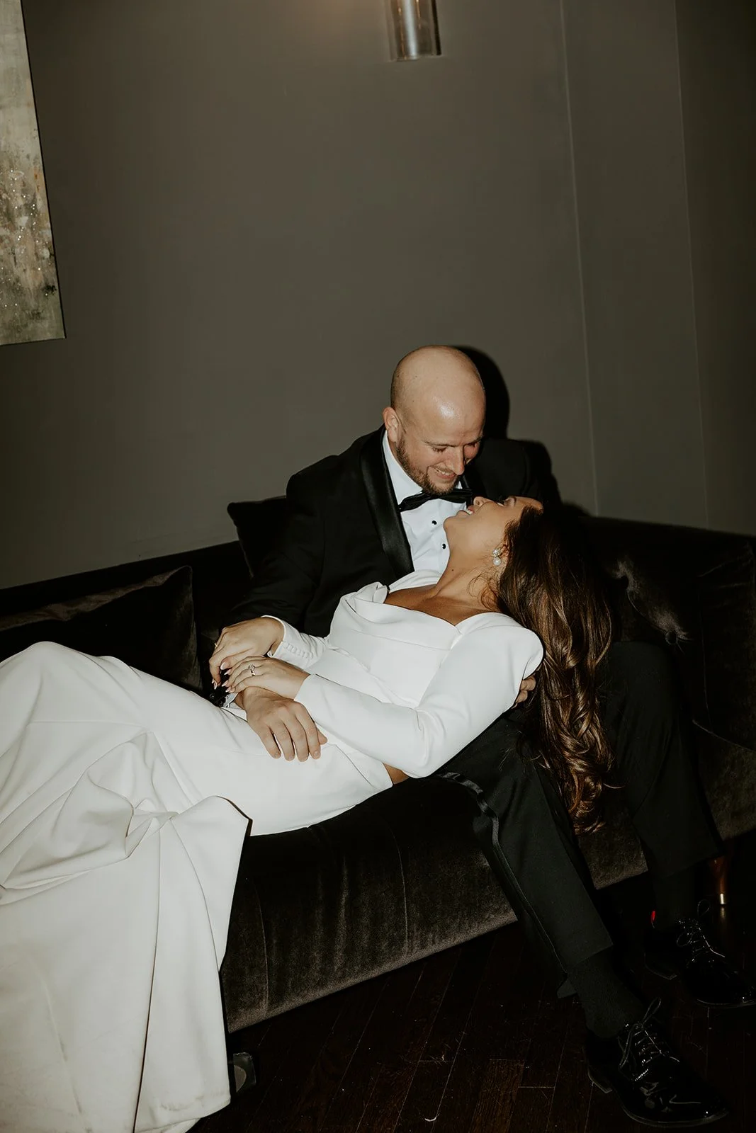A couple on a couch posing for wedding portraits