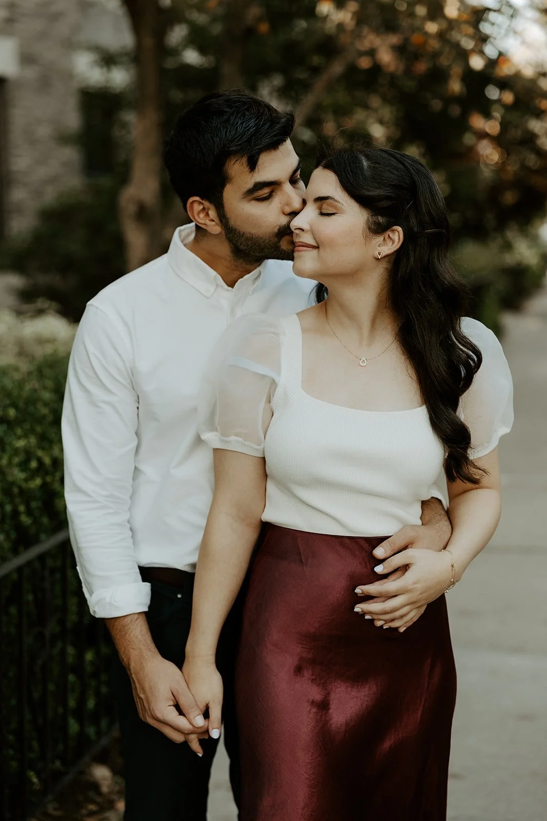 A couple posing for engagement photos in red showing what to wear for engagement photos
