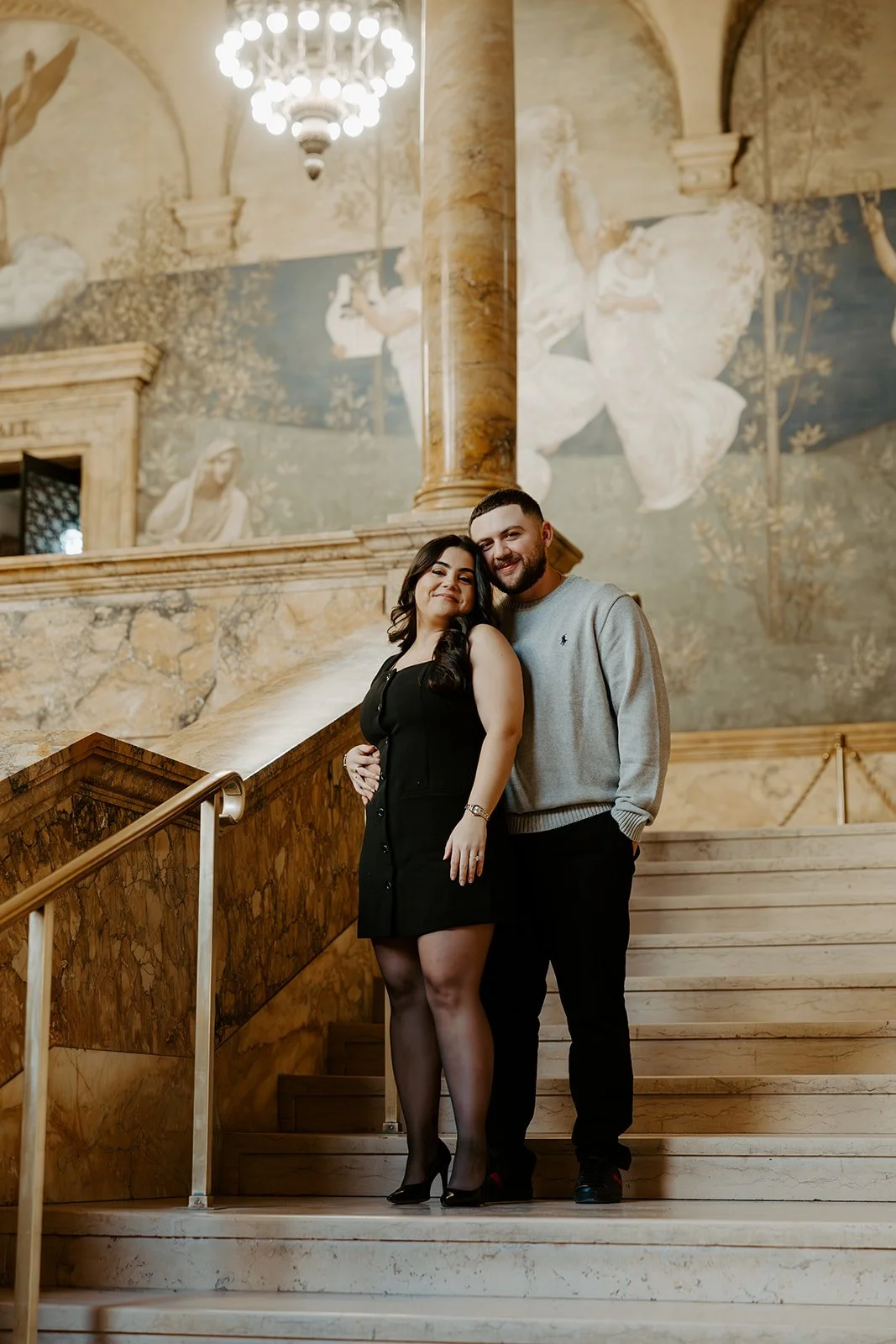 A couple taking engagement photos inside the Boston Public Library