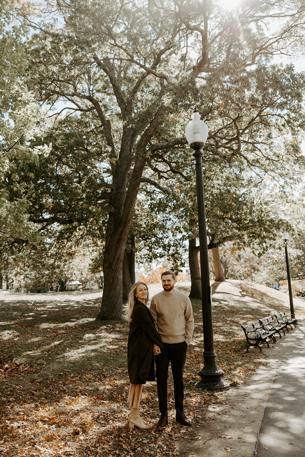 A couple walking through a park showing what to wear for engagement photos