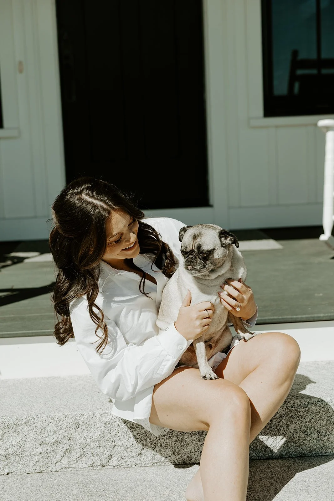 A bride holding her dog while getting ready for her wedding