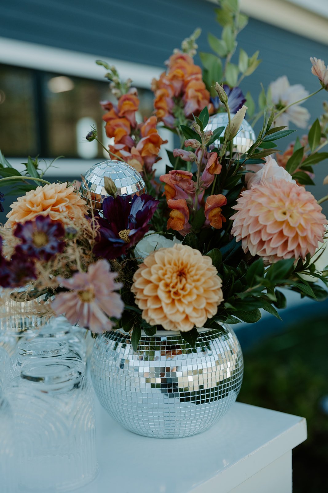 A floral arrangement in a disco ball vase for ideas for a backyard wedding
