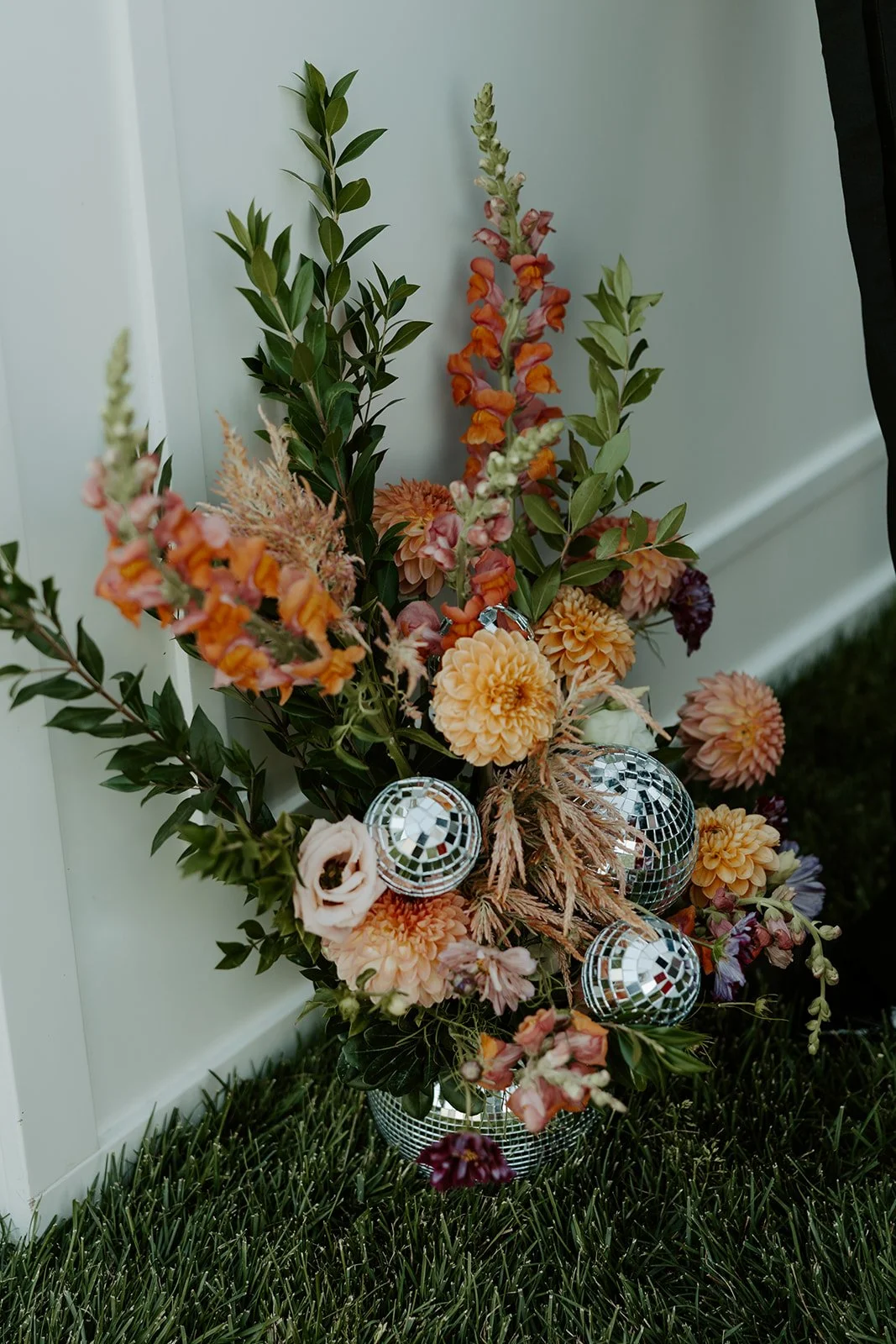 A floral arrangement in a disco ball vase for ideas for a backyard wedding