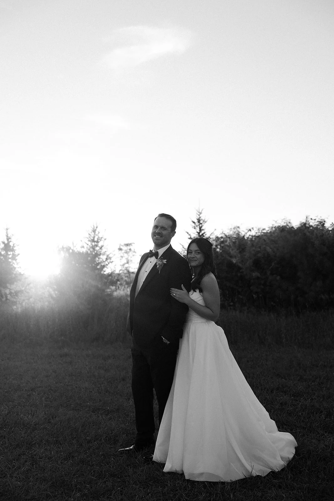 A bride and groom posing for sunset wedding photos