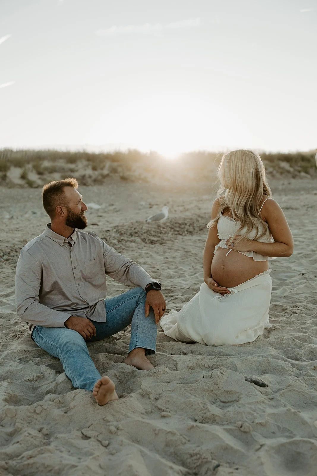 A couple posing for beach maternity photos