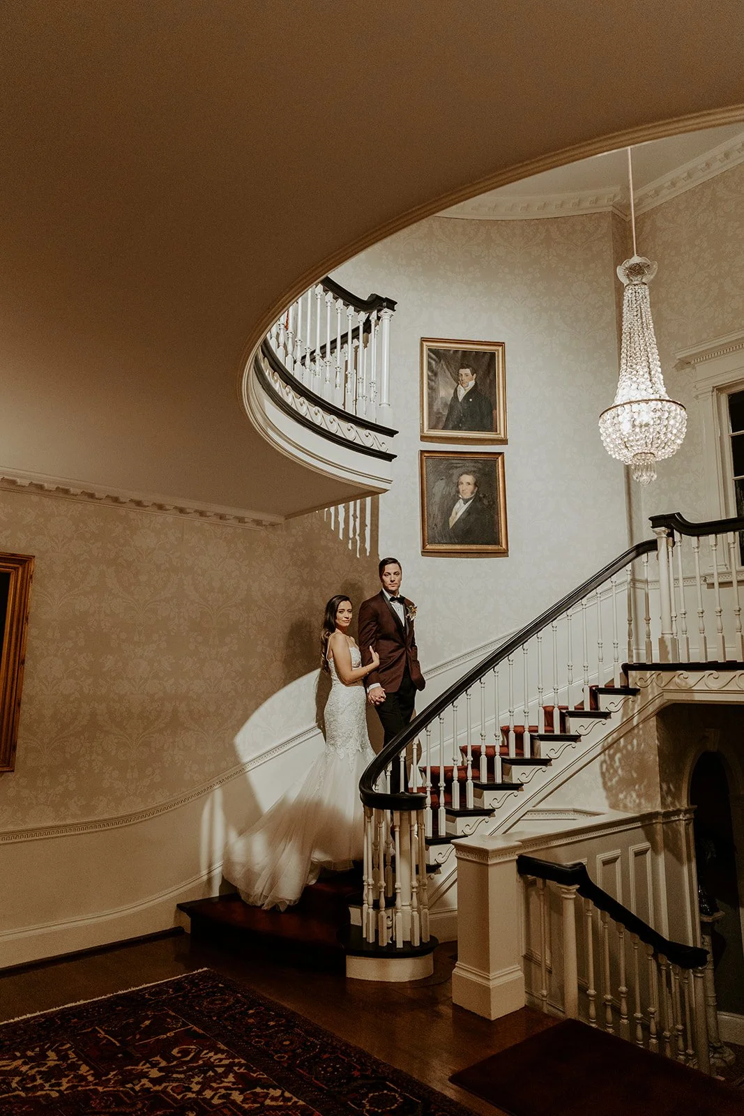 A bride and groom walking up a spiral staircase