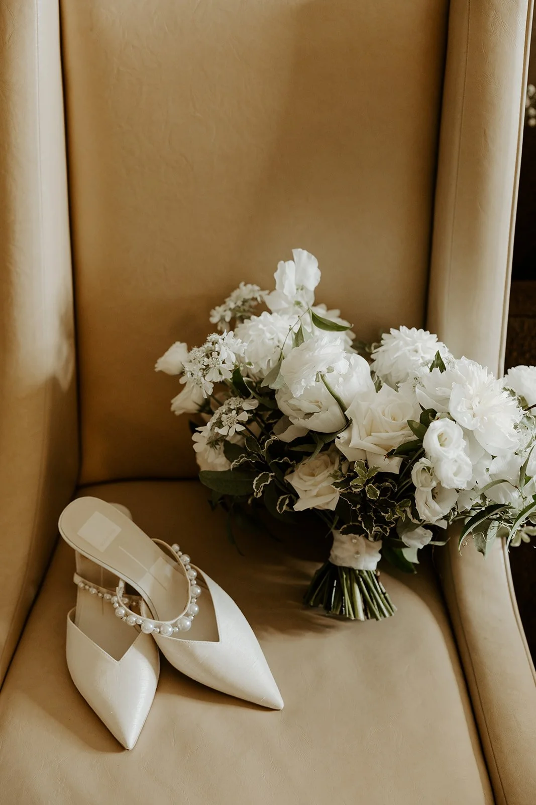 Wedding shoes and a bridal bouquet on a chair