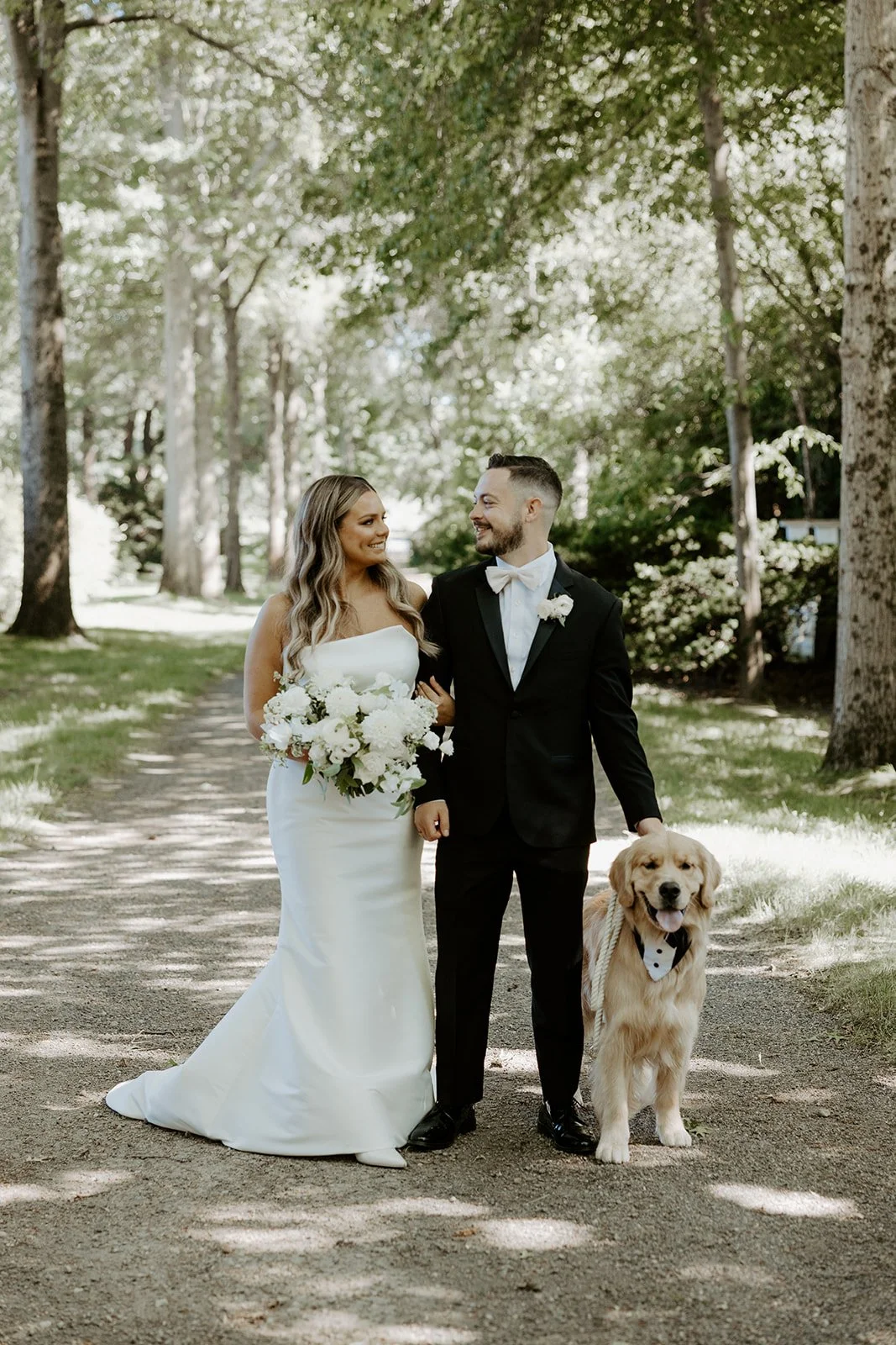 A bride and groom taking wedding photos with their dog