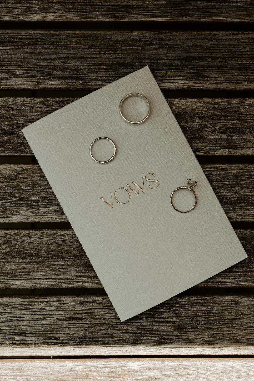 A wedding vow book with wedding rings lying on top of it