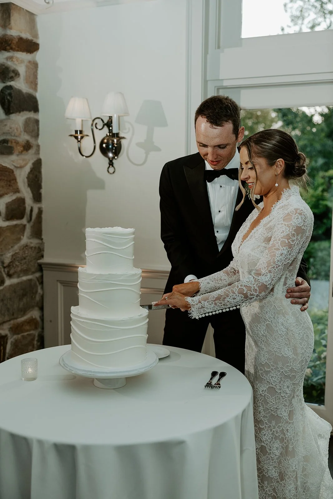A bride and groom cutting their cake at their boston wedding