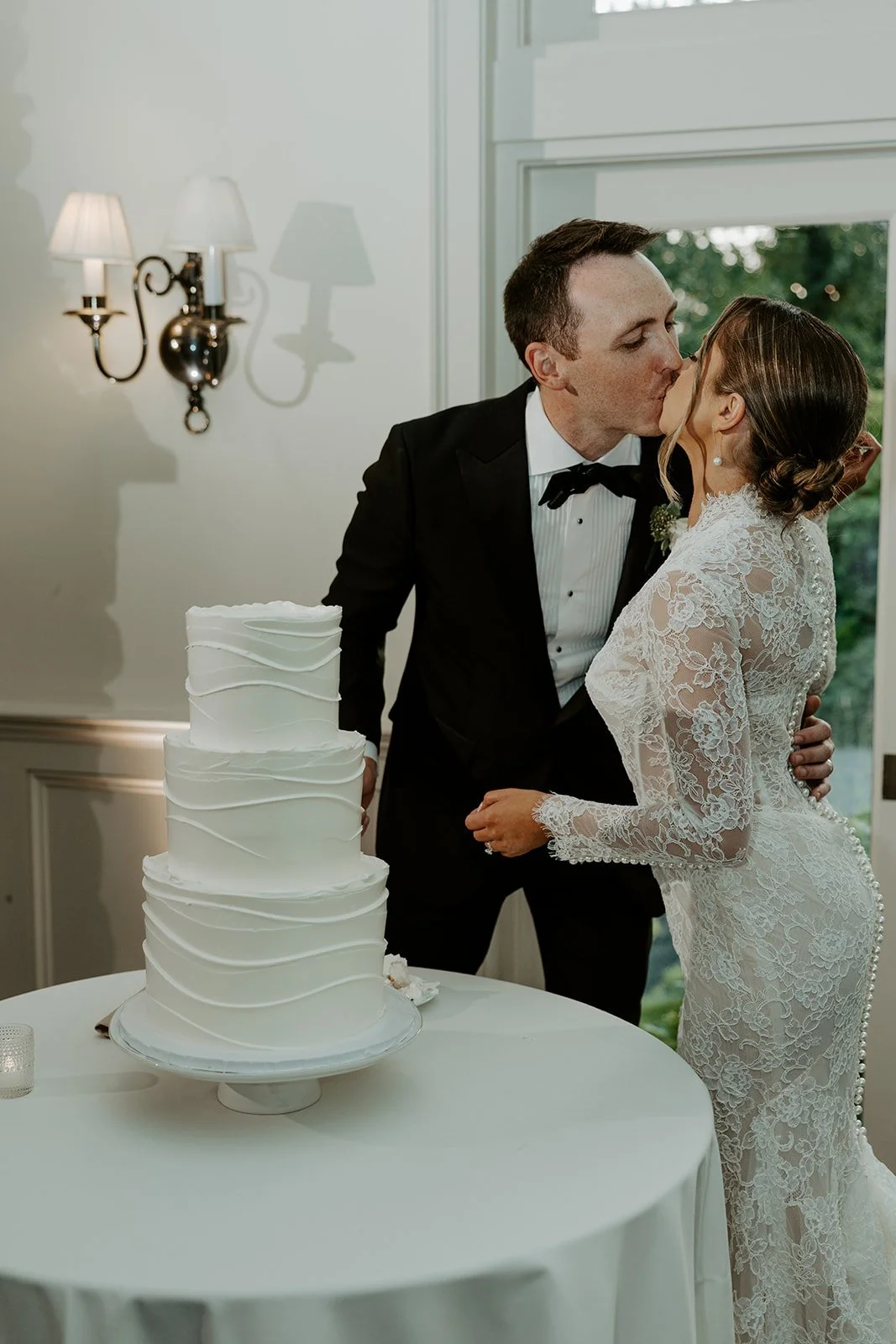 A bride and groom cutting their cake at their boston wedding