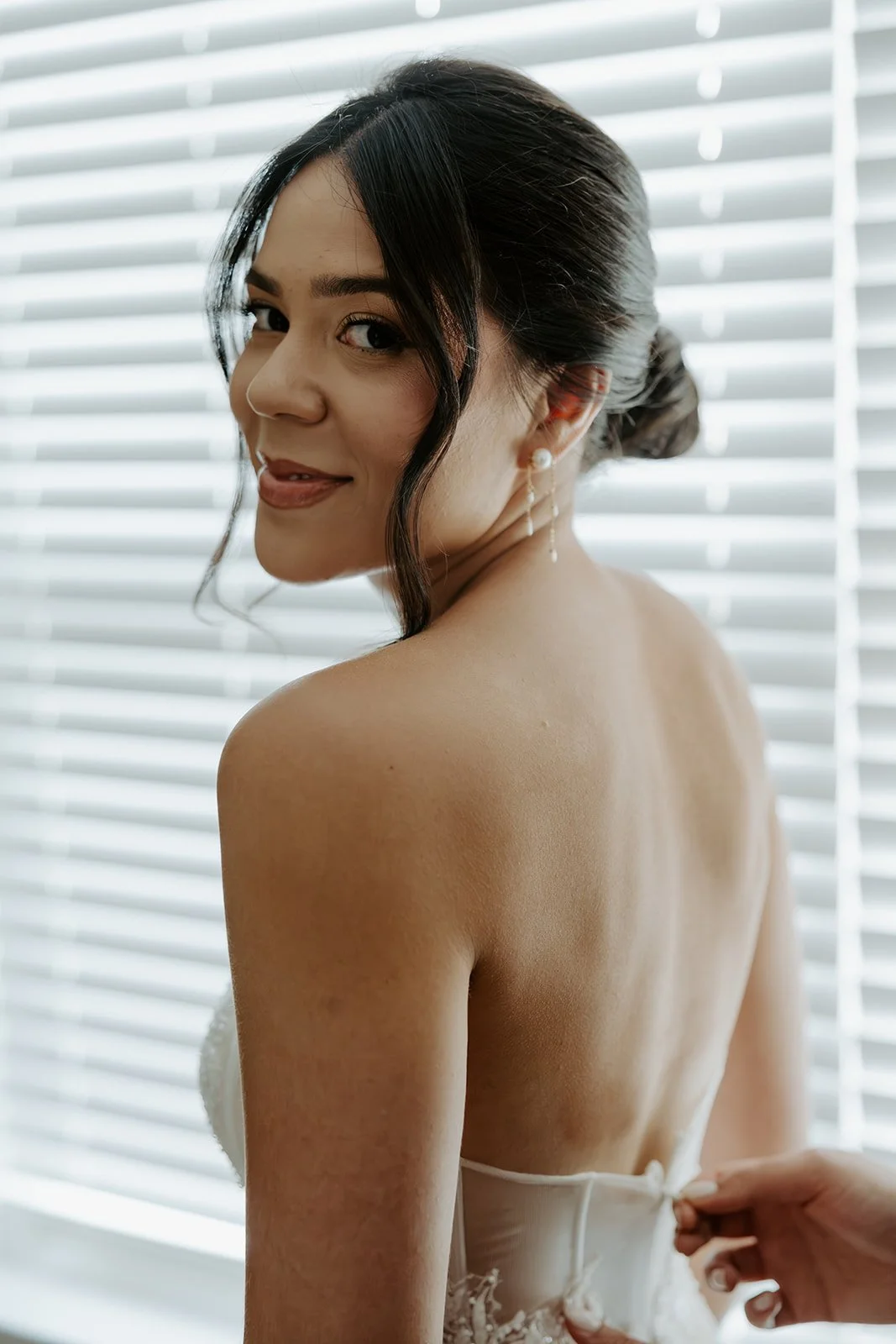 A bride's mom zipping up her wedding dress
