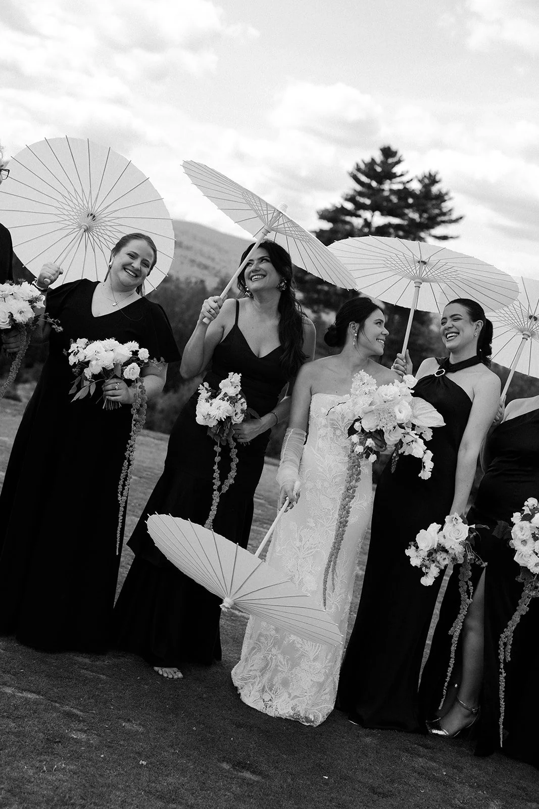 A bride and bridesmaids posing with parasols