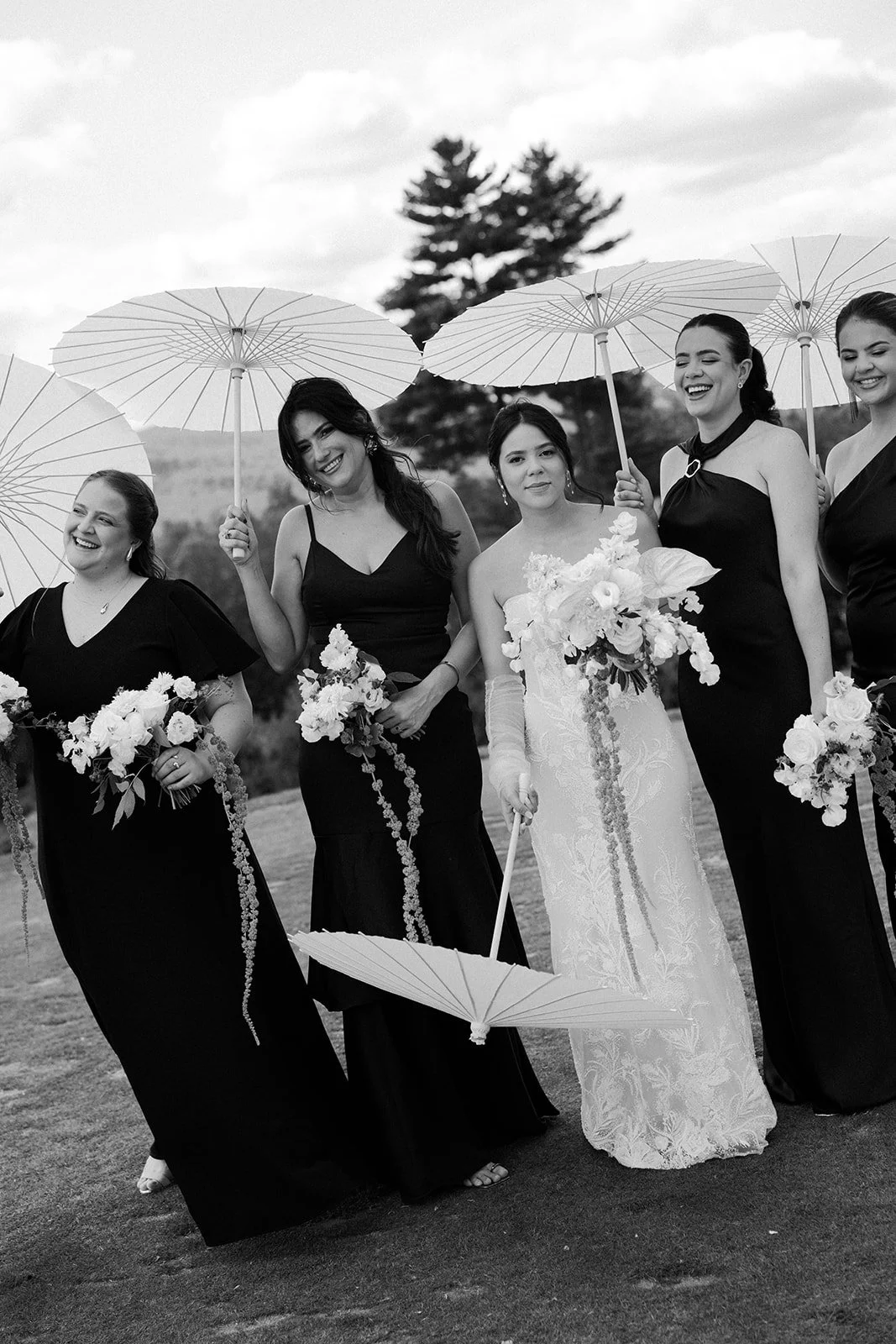 A bride and bridesmaids posing with parasols