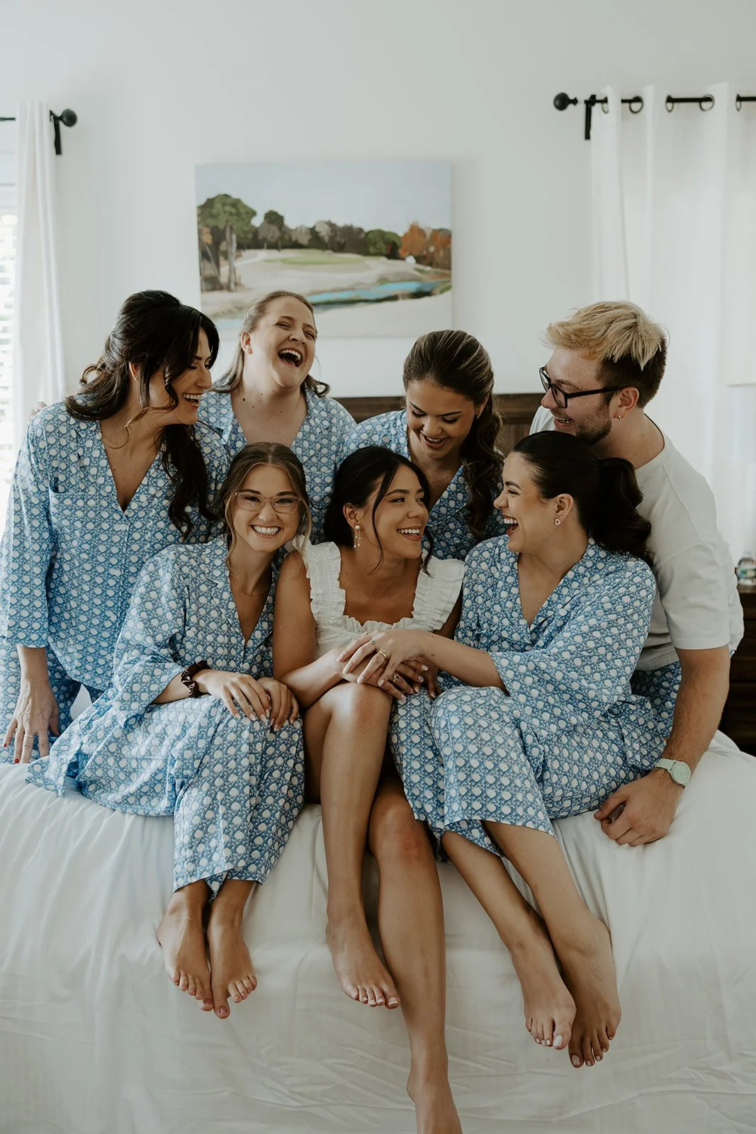 A bride and her bridal party laughing