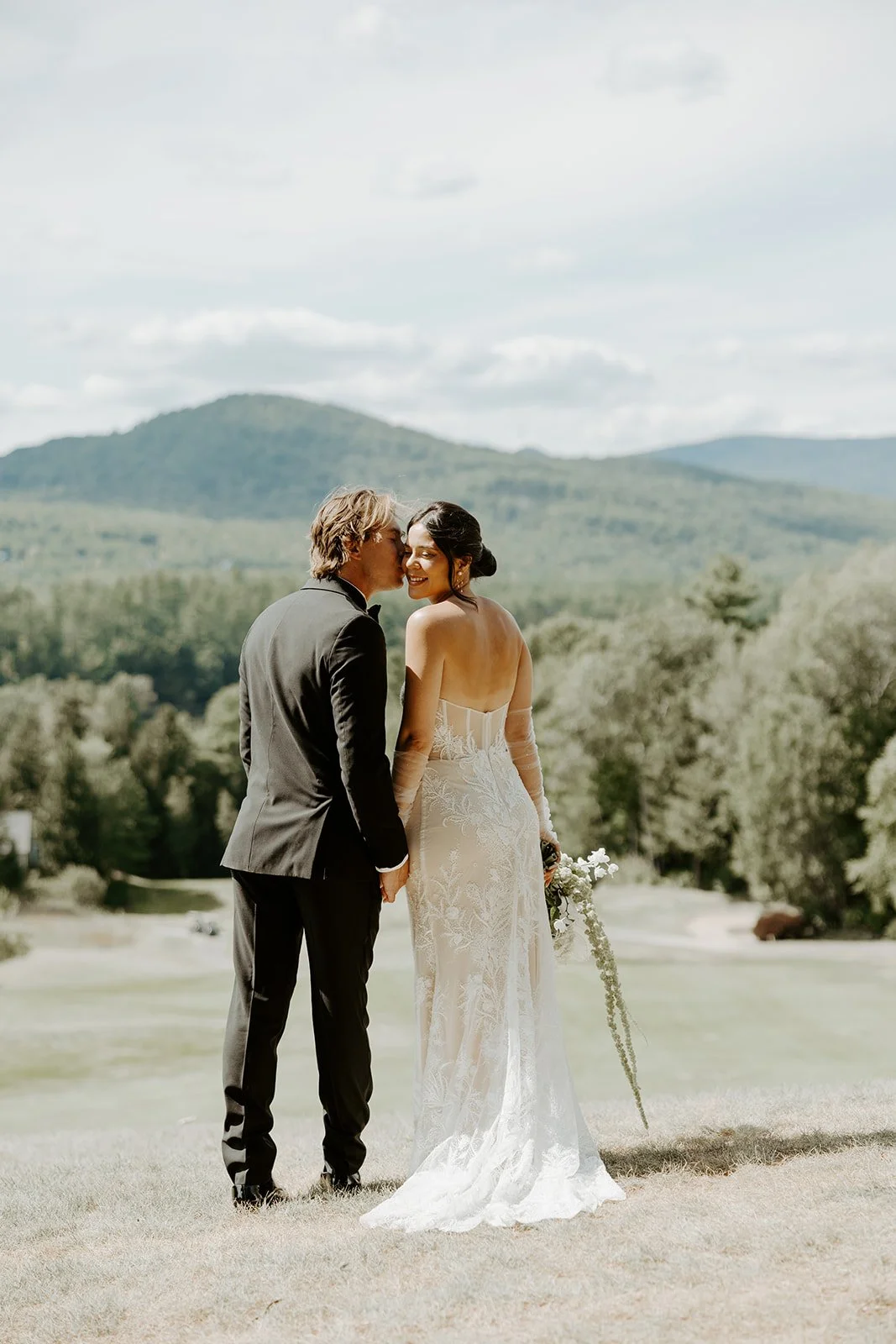 A bride and groom taking wedding photos in front of mountains