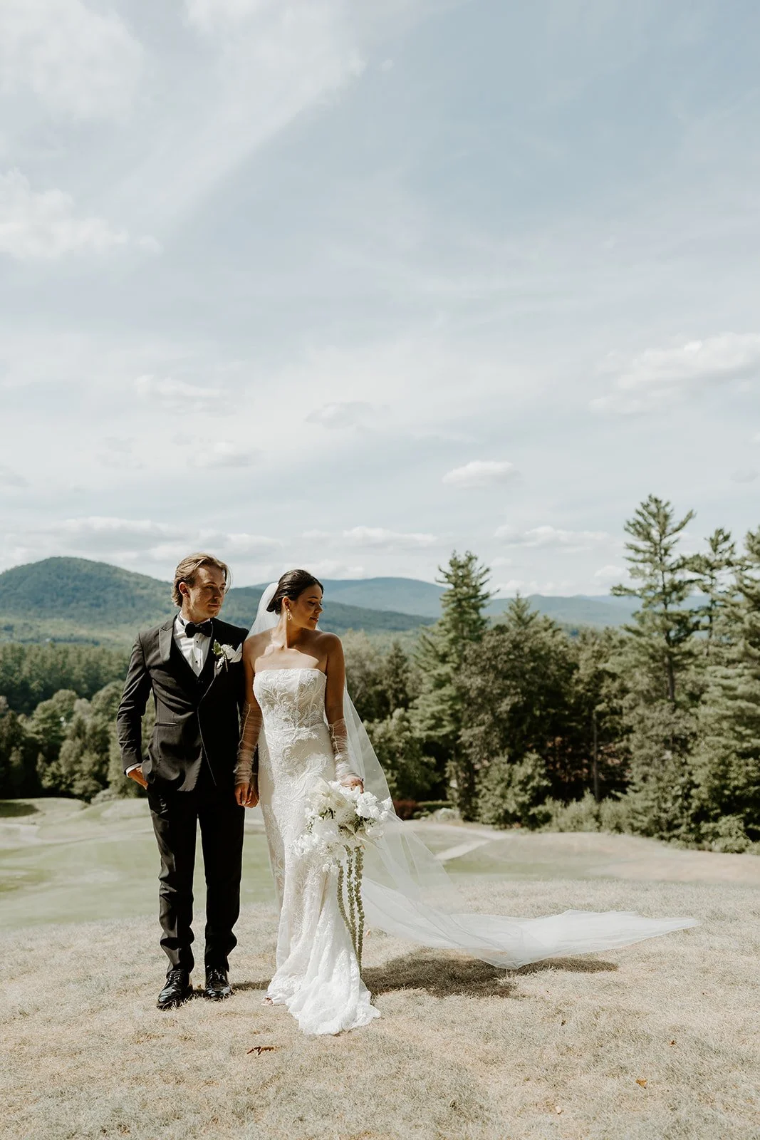 A bride and groom taking wedding photos in front of mountains