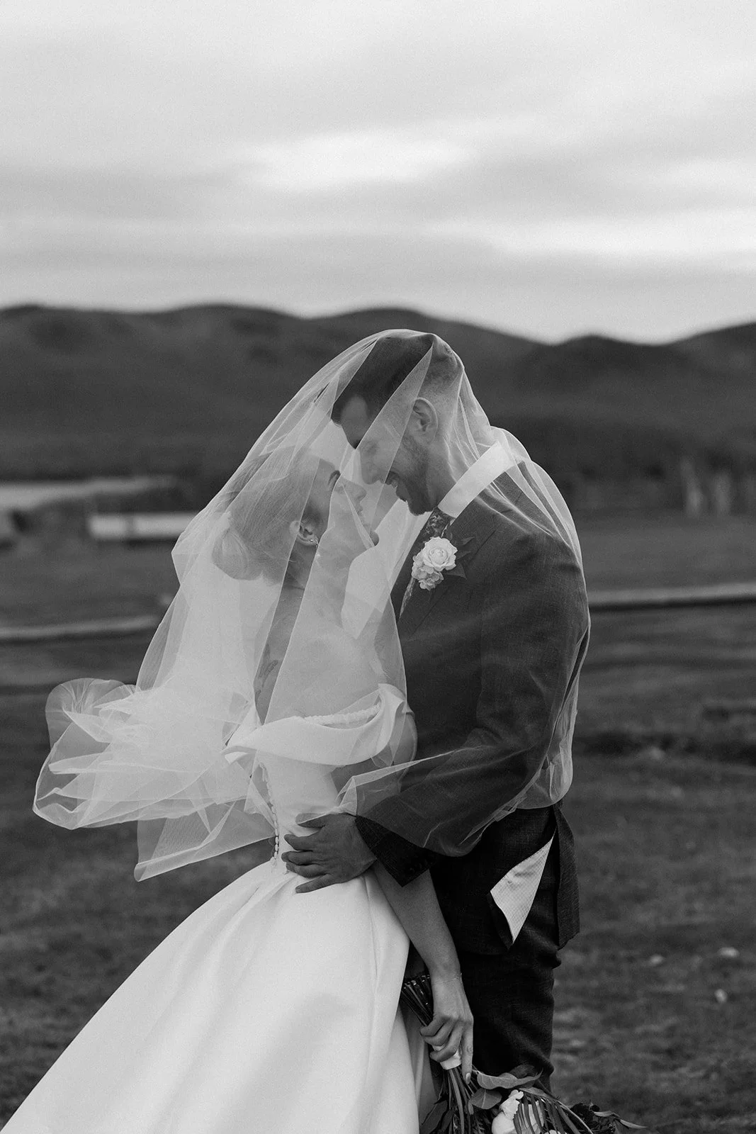 A bride and groom in a black and white wedding photo at their Vermont wedding venue