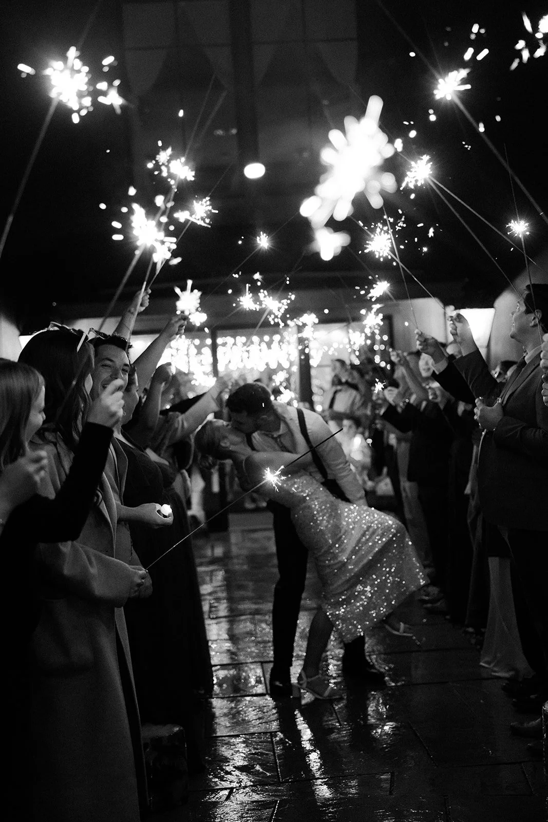 A bride and groom leaving their wedding through a sparkler exit