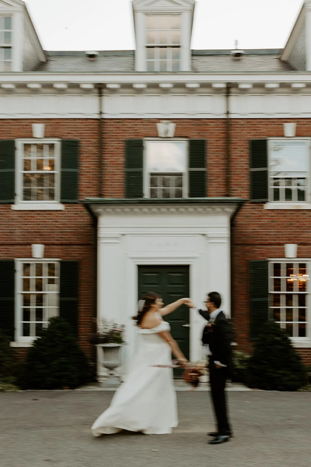 A bride and groom dancing in front of the mansion at the bradley estate