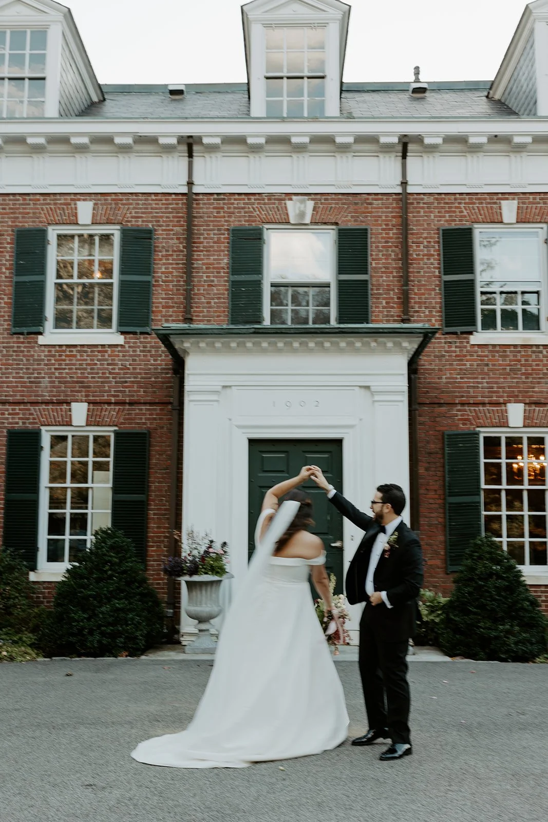 A bride and groom dancing in front of the mansion at the bradley estate