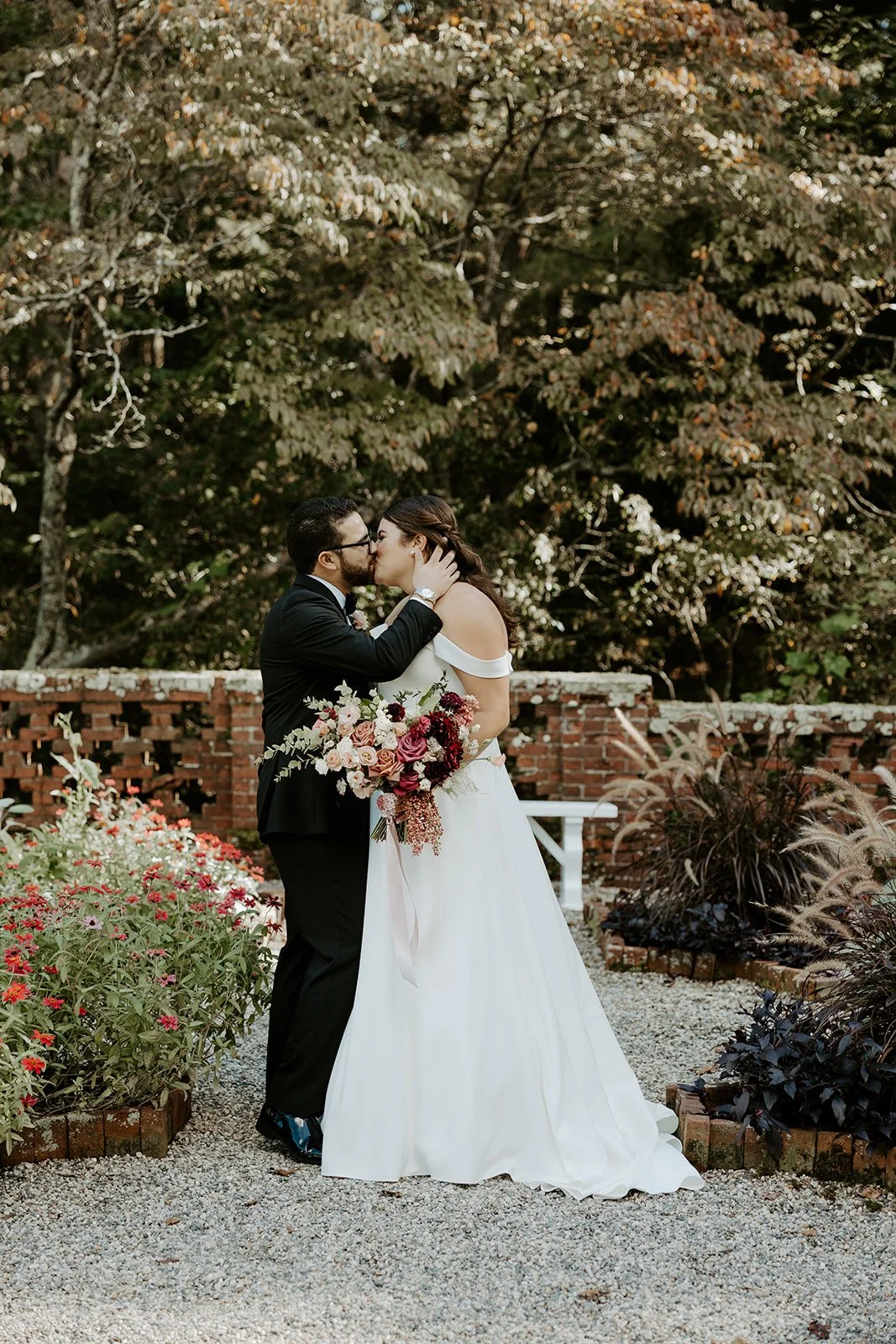 A bride and groom posing for wedding photos in the gardens at the bradley estate