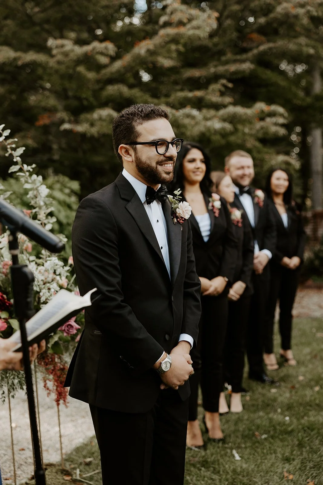 A groom watching a bride walk down the aisle