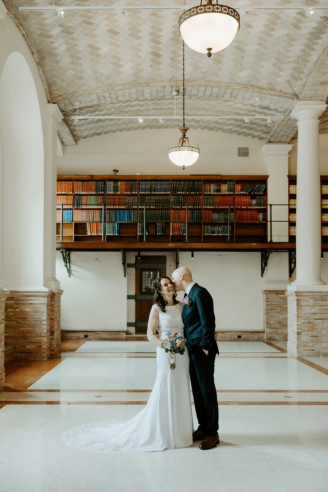 A bride and groom taking elopement photos in boston public library