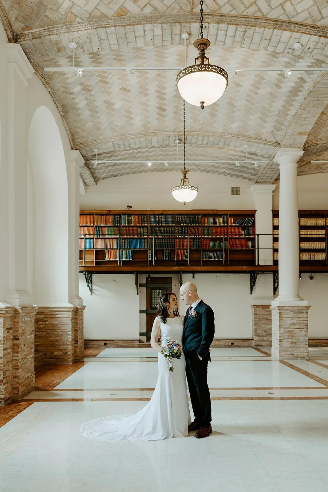 A bride and groom taking elopement photos in boston public library