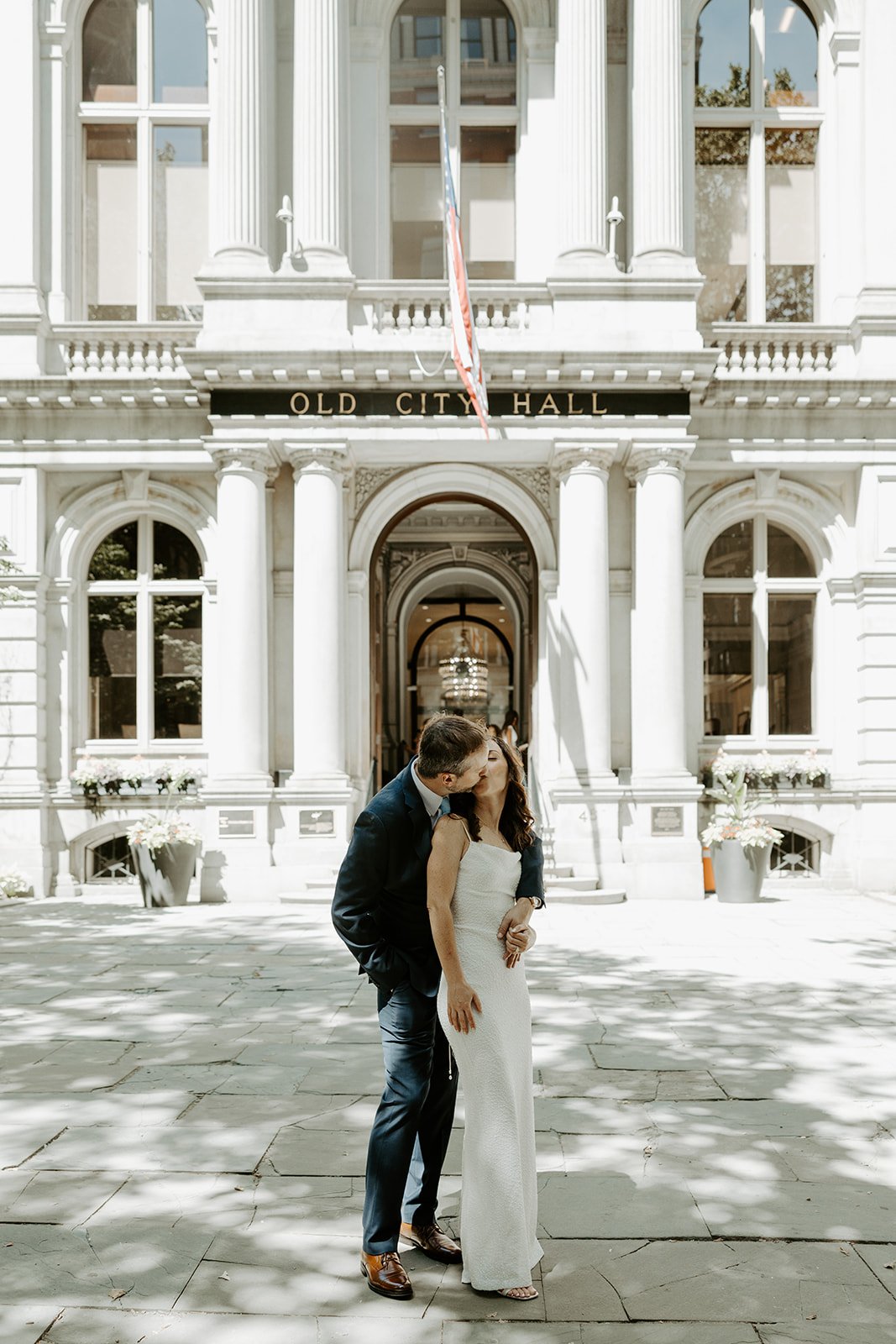 A bride and groom posing for city hall wedding photos