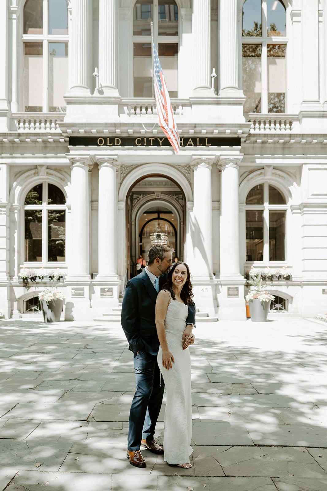 A bride and groom posing for city hall wedding photos