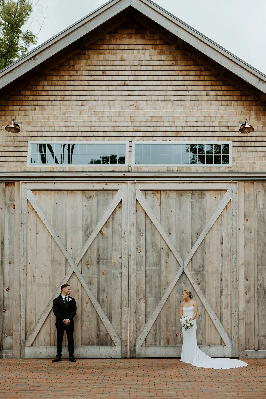 A bride and groom posing at their barn new hampshire wedding venue