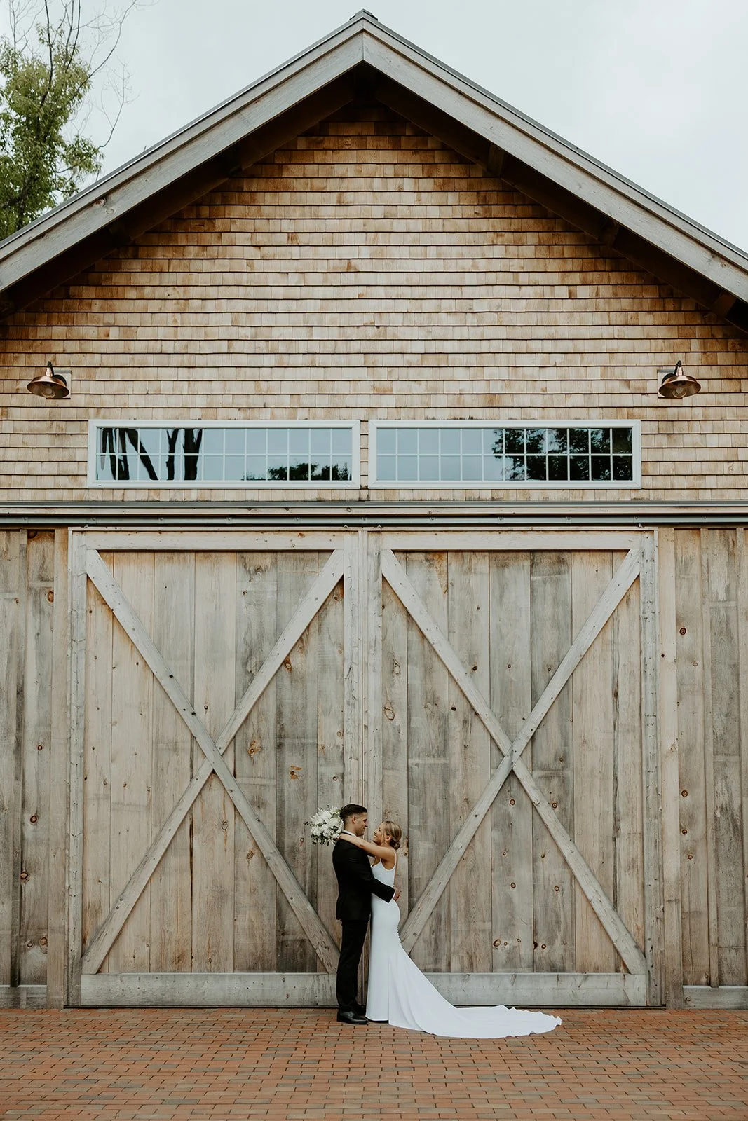 A bride and groom posing at their barn new hampshire wedding venue