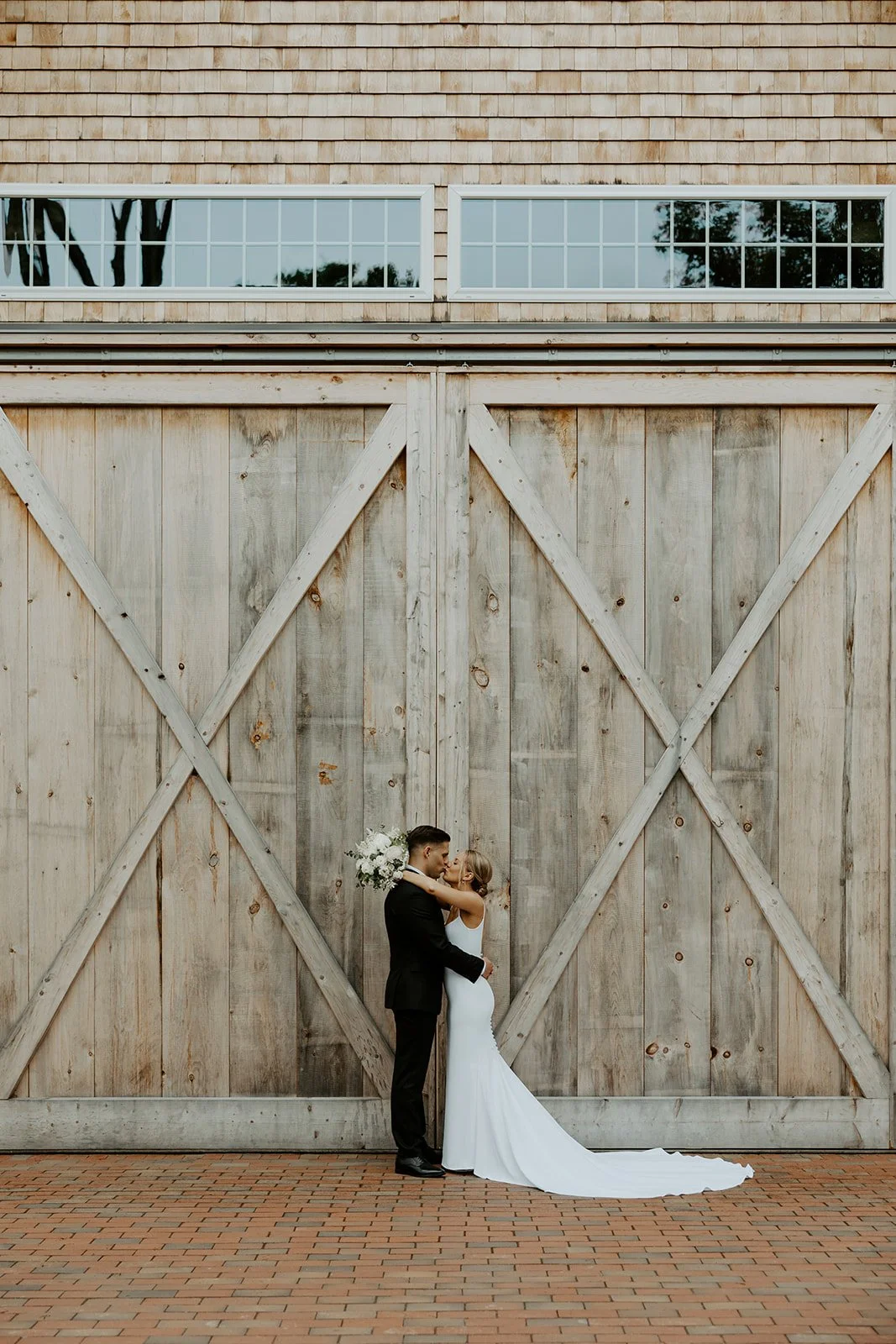 A bride and groom posing at their barn new hampshire wedding venue