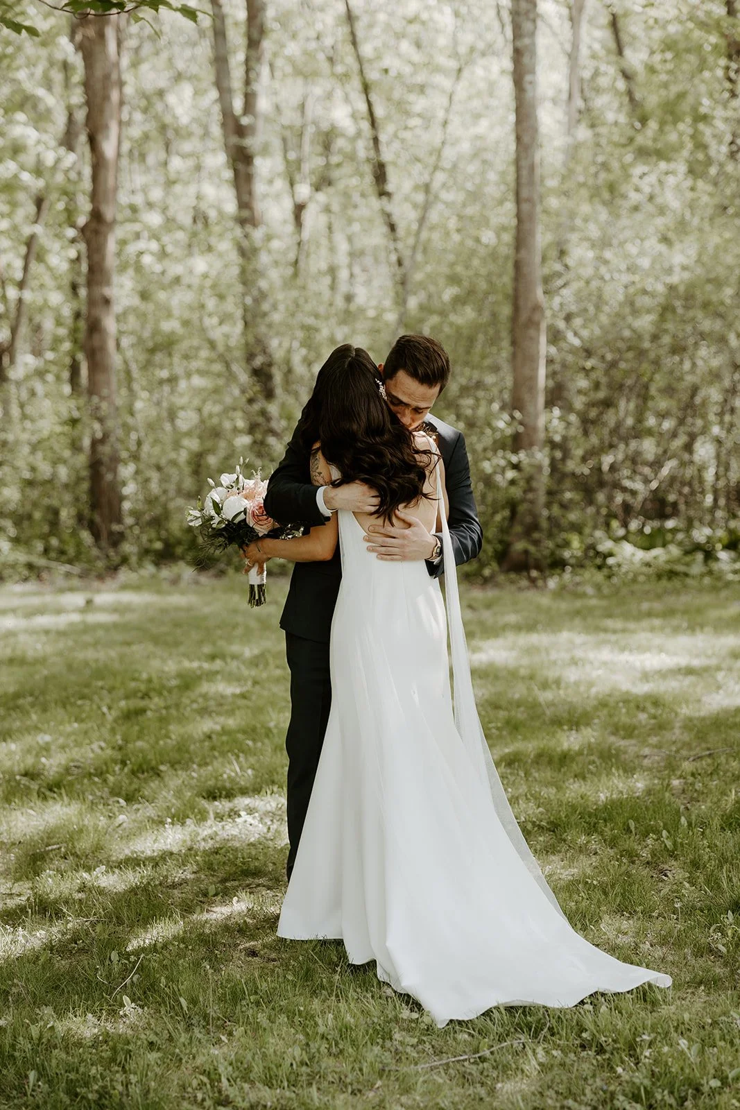 A bride and groom hugging in candid wedding photos during their first look