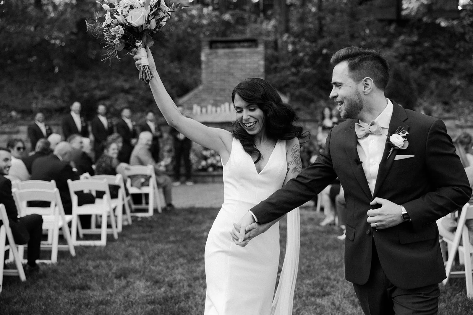 A bride and groom cheering after their wedding ceremony