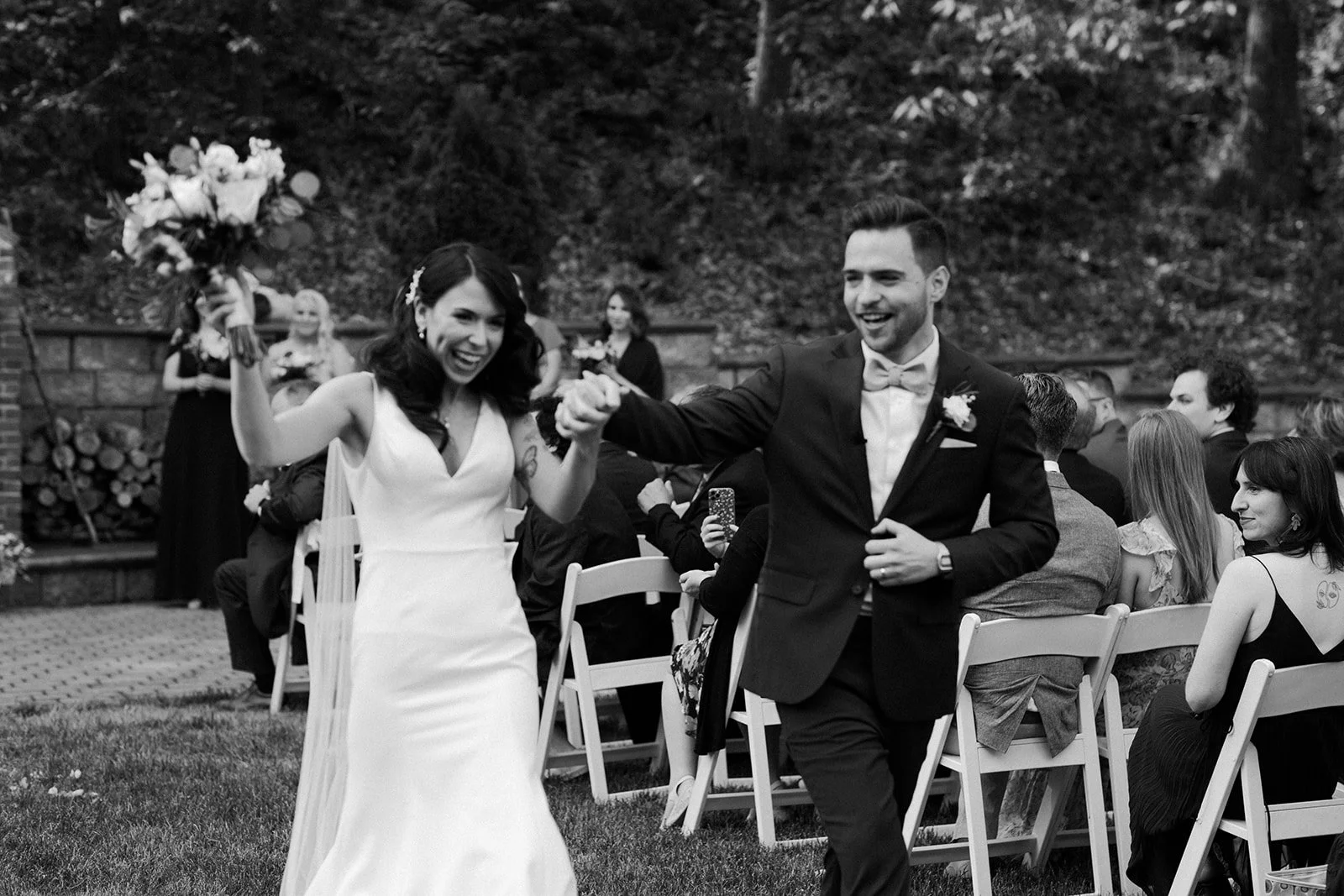 A bride and groom cheering after their wedding ceremony