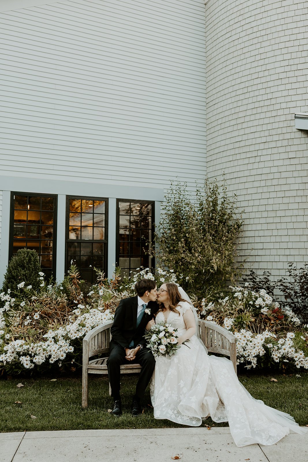 A couple posing for wedding photos in a garden at the grove